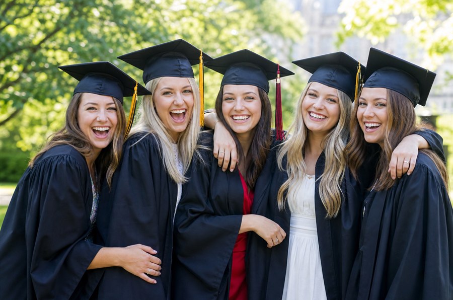 Happy women graduates celebrating at university convocation